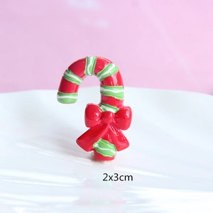 Macro view of a red and green resin candy cane with bow, 2x3cm DIY Christmas accessory