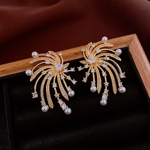 Detail of gold starburst earrings with white pearls on a black velvet jewelry tray