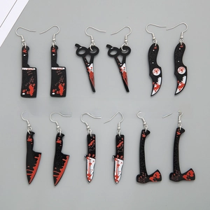 Macro shot of Halloween acrylic bloody weapon earrings including saws and axes