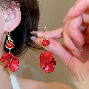 Detailed close-up of red petal tassel earrings with elegant gold metallic finish