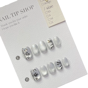Silver cat-eye press-on nails with black bamboo leaf hand-painted designs