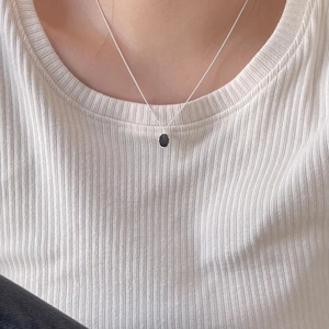 Minimalist S925 sterling silver necklace with a black oval pendant on a female model