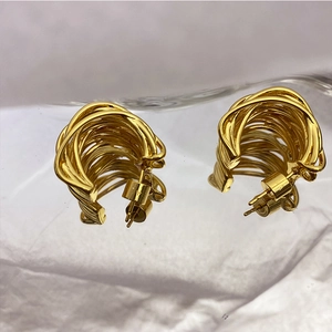 Close-up of gold hollow interlaced twisted hoop earrings with 925 silver needles