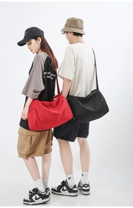 Vue arrière du modèle portant un grand sac de sport en nylon imperméable avec sangle