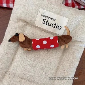 Close-up of a 10cm handmade brown corduroy dachshund dog clip with red polka dot outfit