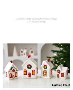 Detail of glowing white ceramic Christmas houses with hand-painted festive wreaths