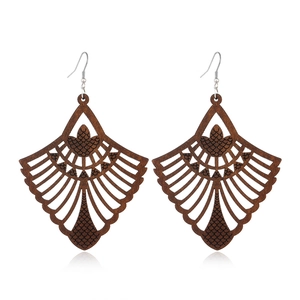 Detail of dark brown wooden fan earrings with hollow pattern and scale texture