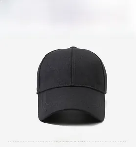 Detail of black cotton baseball cap with long brim and silver shield logo plaque