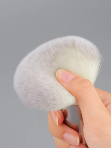 Macro shot of large powder brush with dense, soft bristles showing elasticity and texture