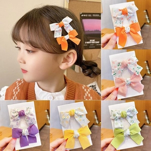 Macro detail of various colorful floral bow hair clips for girls in multiple shades