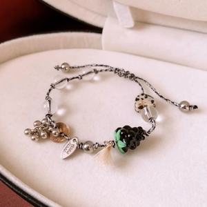 Detailed close-up of handmade beaded bracelet with glass grapes and heart stone