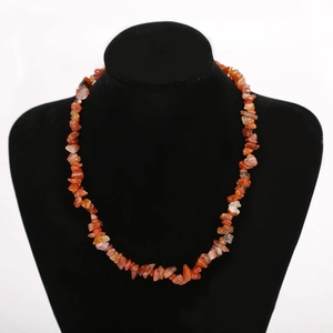 Macro detail of natural red carnelian raw stone beads on a black necklace display