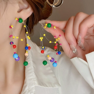 Macro shot of colorful beaded multi-layer hoop earrings with vibrant resin beads and metallic accents