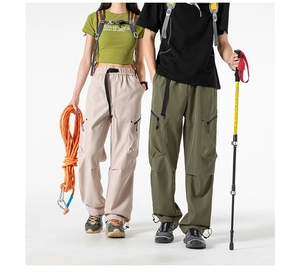 Detail of cargo pants with multi-pocket design, adjustable buckle belt and drawstring hem