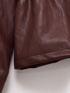 Nahaufnahme der dunkelbraunen Kunstlederjacke mit feiner Textur und präziser Naht