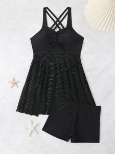 Flat lay of black two-piece swimdress with crochet lace hem and sea star decor