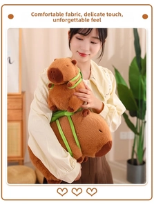 Nahaufnahme von weichem Capybara-Plüschtier mit grünen Trägern in gemütlichem Heim