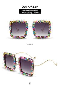 Detail view of gold metal sunglasses with colorful candy-style glitter frames and grey lenses