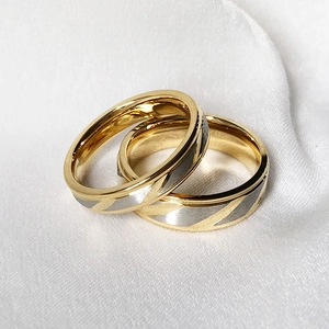 Minimalist gold titanium steel couple rings featuring diagonal silver grey texture accents