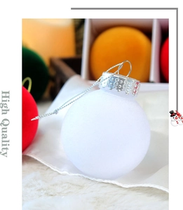 Gros plan sur une boule de Noël blanche floquée avec capuchon argenté et texture
