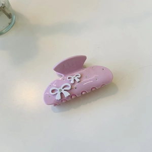 Pince à cheveux rose en acétate avec nœuds blancs et strass scintillants