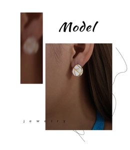 Close-up of elegant gold and white enamel geometric earrings worn by an Asian model