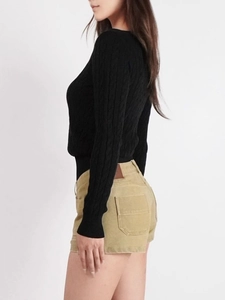 Slim fit black cable knit V-neck sweater paired with khaki corduroy shorts on model