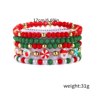 Detail of Christmas beaded bracelet set with Santa and candy charms on white background