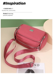 Detalle de bolso bandolera de nailon rosa oscuro con múltiples bolsillos y correa ancha