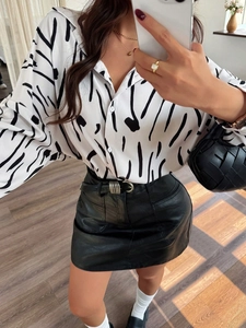 Camicia casual a maniche lunghe stampata con gonna in pelle nera e borsa a mano