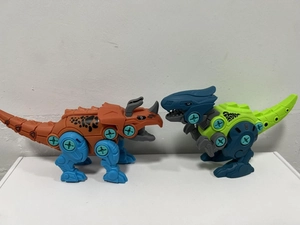 Detail of buildable dinosaur toy set featuring Triceratops and T-Rex with visible plastic bolts