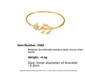 Détail du bracelet en acier plaqué or 18k avec tortue de mer, zircon et perle de coquillage