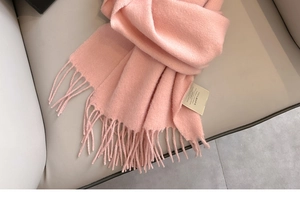 Detail of 100% Australian wool scarf texture with soft fringe edges and fabric label