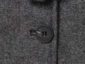 Gros plan sur les boutons marbrés d'une veste blazer en tweed gris pour femme