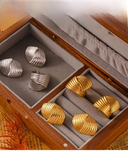 Detailed view of 18K gold and silver pleated texture jewelry set in a wooden display box