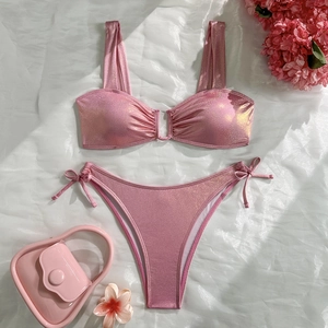 Detailed view of sparkly pink two-piece bikini with side-tie bottoms and shimmering fabric