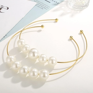 Minimalist gold open collar necklace with five gradient pearls on white background