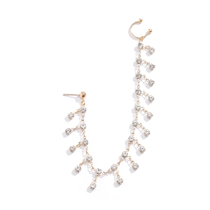 Punk style gold earring with tassel chain and rhinestones on a white background