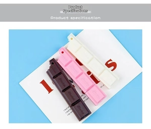 Detailed view of chocolate bar shaped novelty pens in brown, pink and cream colors