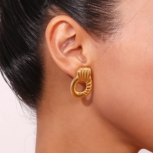 Close-up of elegant 18K gold-plated stainless steel twisted hoop earring on model's ear
