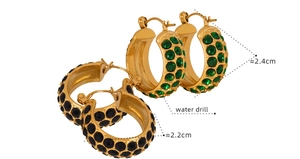 Detail of vintage C-shaped gold earrings with sparkling green and black rhinestones