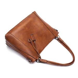Detail view of brown PU leather shoulder bag featuring metal rings and precise stitching