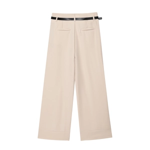 Detail of apricot wide-leg pants featuring a clean fabric texture and slim black belt accent
