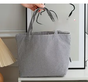 Close-up of black and white striped canvas tote bag in a minimalist home setting