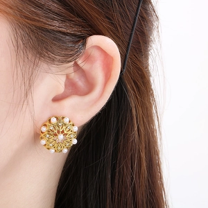 Vintage hollowed-out gold earrings with white pearls and sparkling diamond accents