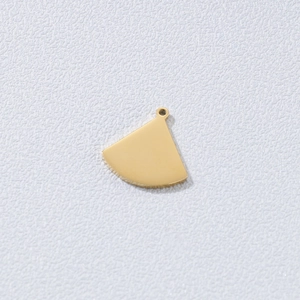 Macro shot of polished gold-finished fan-shaped titanium steel pendant for jewelry DIY