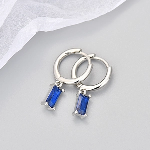 Macro shot of S925 sterling silver hoop earrings with rectangular blue zircon charms