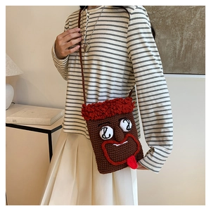 Braune gestrickte Umhängetasche mit lustigem Gesicht Design am Model präsentiert