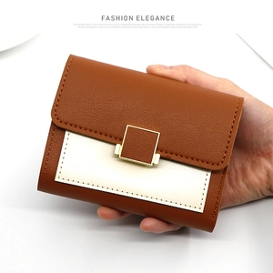 Gros plan du portefeuille en cuir bicolore avec boucle dorée et texture grainée fin