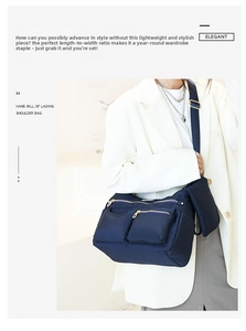 Navy blue water-resistant nylon crossbody bag with gold zippers worn with white blazer